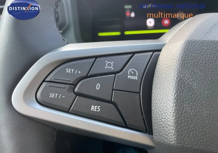 Gros plan sur les commandes au volant du Dacia Duster 2024 noir métal, mettant en valeur les boutons de régulateur de vitesse.