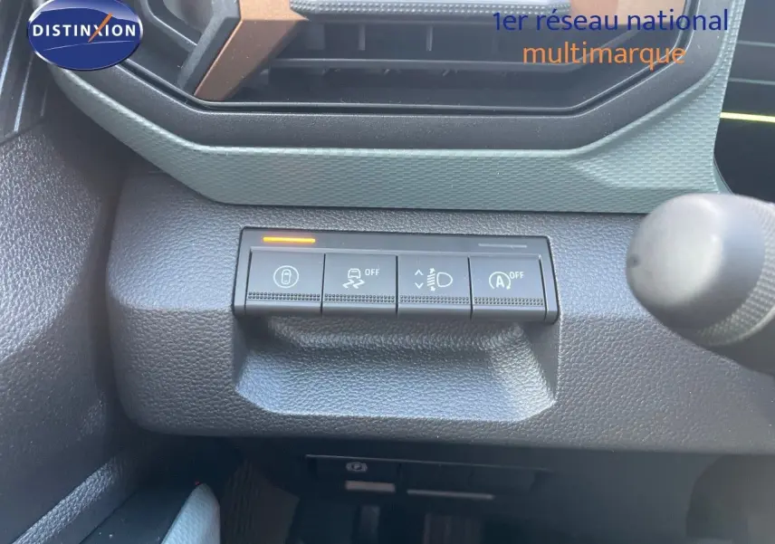 Gros plan sur les commandes de sécurité et d'éclairage du tableau de bord d'un Dacia Duster noir métal 2024.
