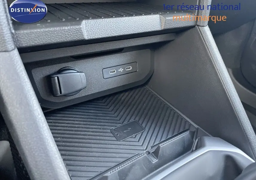 Prise USB et prise 12V dans le rangement central avant du Dacia Duster 2024 noir métal, côté passager.
