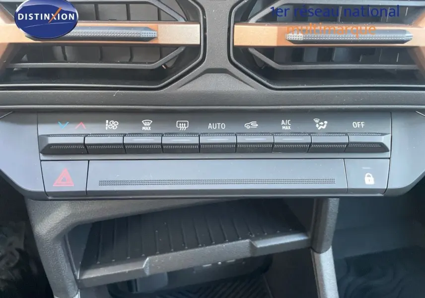 Vue rapprochée de la console centrale du Dacia Duster 2024 noir métal, mettant en valeur les commandes de climatisation et les aérateurs.