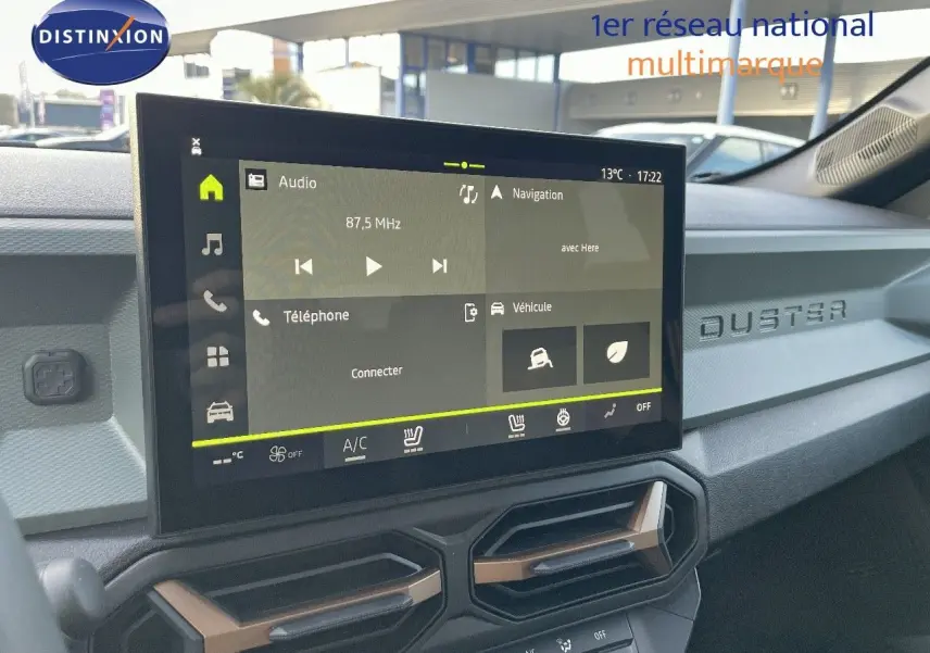 Vue rapprochée de l'écran tactile central et tableau de bord noir du Dacia Duster 2024 avec inscription DUSTER en relief.