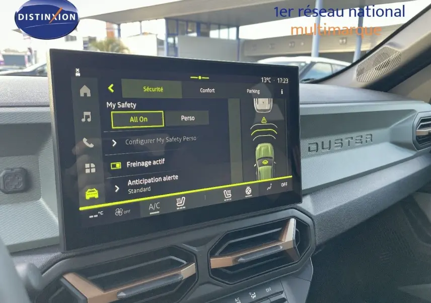 Vue intérieure du tableau de bord du Dacia Duster 2024 noir métal, avec écran tactile central et inscription DUSTER en relief.