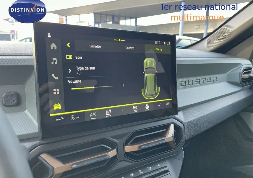 Vue intérieure du tableau de bord du Dacia Duster 2024, écran tactile central affichant les réglages audio et climatisation.