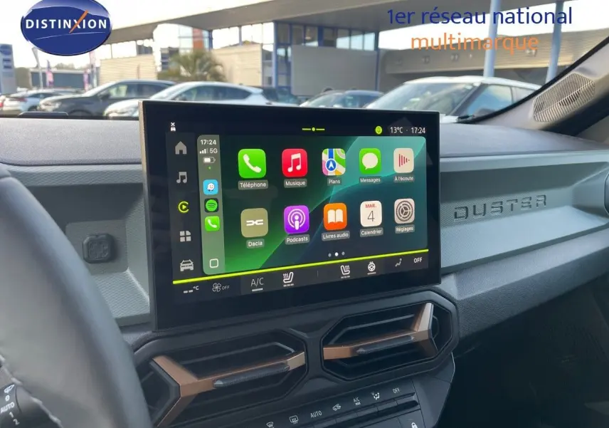 Vue intérieure du tableau de bord du Dacia Duster 2024 noir métal, avec écran tactile central et détails modernes.