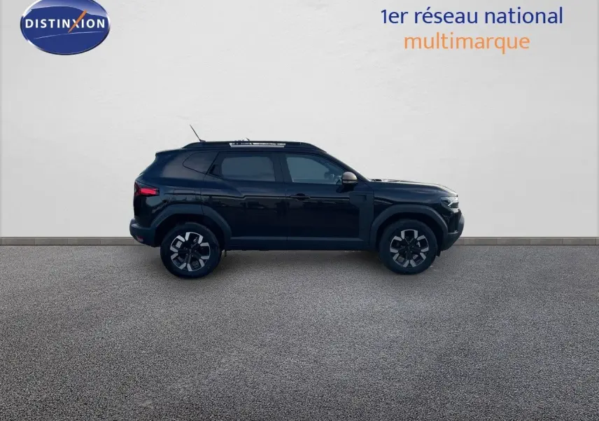 Profil droit d'un Dacia Duster 2024 noir métal avec jantes bi-ton et barres de toit visibles sur fond neutre.
