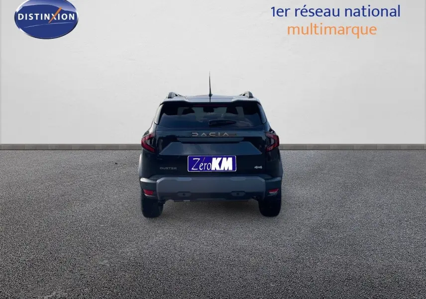 Vue arrière d'un Dacia Duster noir métal 2024 avec logo et plaque Zéro KM sur fond neutre.