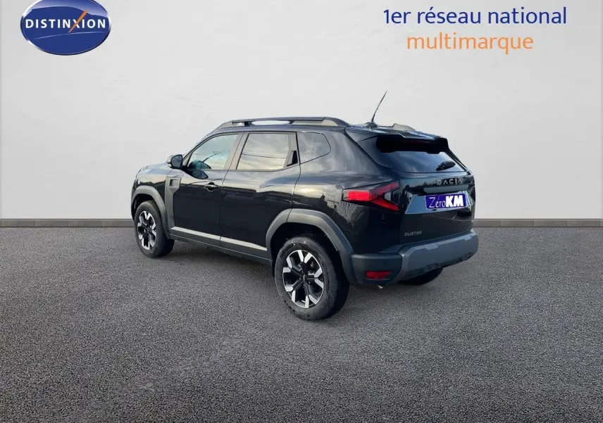 Vue 3/4 arrière d'un Dacia Duster noir métal 2024 avec jantes bi-ton et barres de toit sur fond neutre.