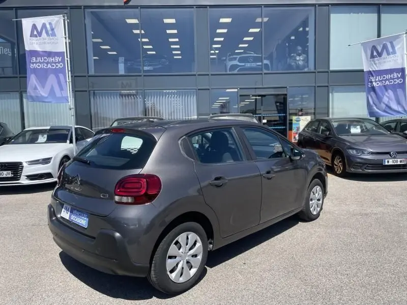 Citroën C3 82 CV Feel gris foncé métal vue 3/4 arrière côté droit sur parking devant concession.