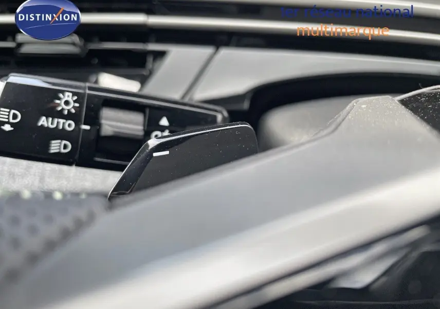 Gros plan sur la palette de changement de vitesse et le commodo des phares du Peugeot 5008 noir perle métal.