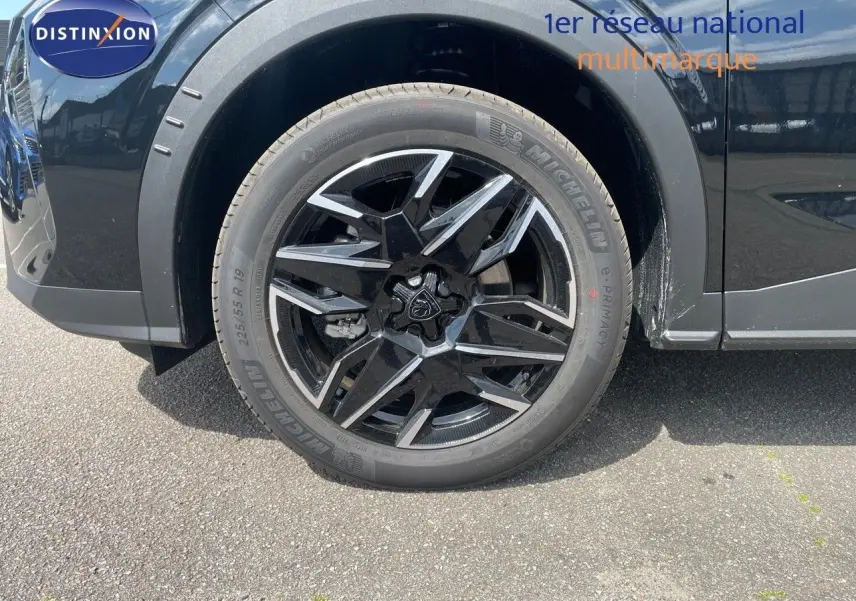 Gros plan sur la roue avant gauche noire et argentée du Peugeot 5008 HYBRID 136CH E-DCS6 GT noir perle métal.