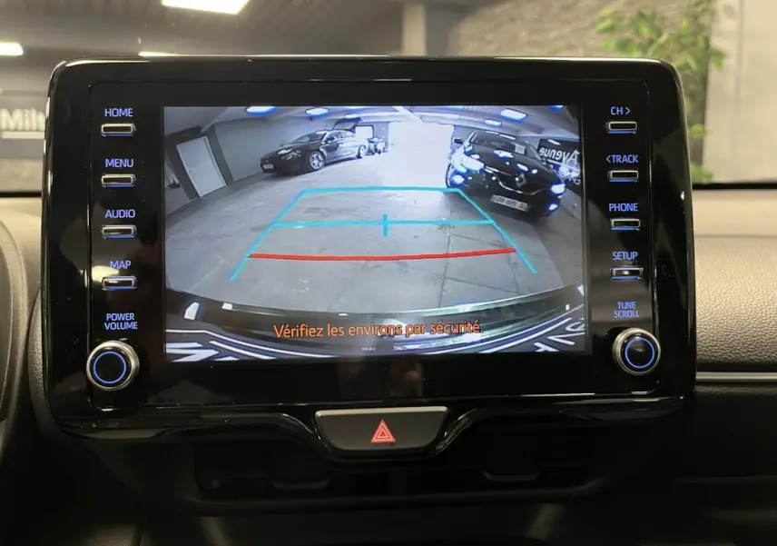 Écran de caméra de recul dans une Mazda2 noire 2023, montrant l'arrière en intérieur de garage.