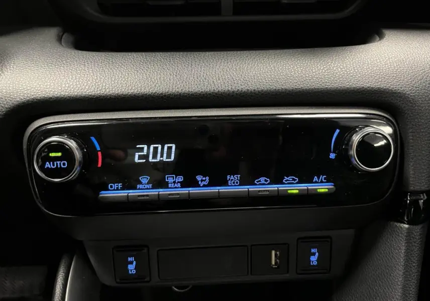 Gros plan sur la commande de climatisation automatique de la Mazda2 noire, affichant 20°C avec boutons éclairés en bleu.