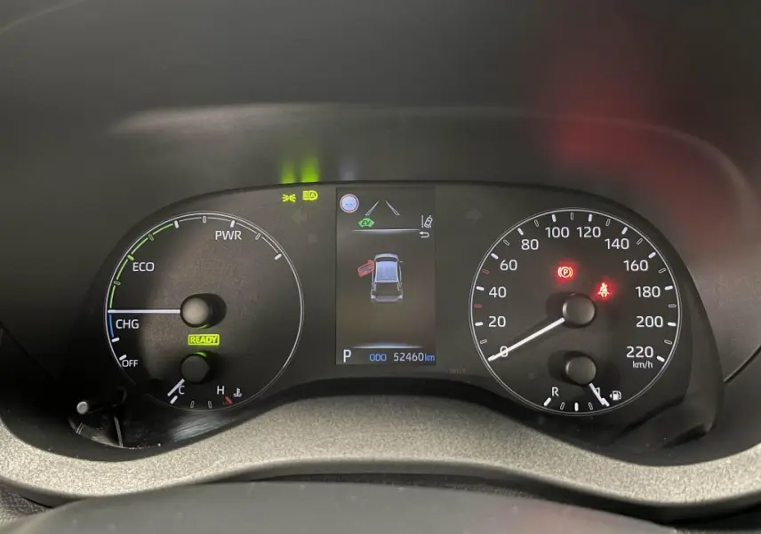 Tableau de bord de Mazda2 1.5 Hybrid 2023 montrant compteurs analogiques et écran central avec alertes et kilométrage.