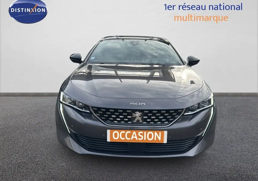 Vue frontale d'une Peugeot 508 gris platinium 2020 avec calandre distinctive et feux LED fins allumés.