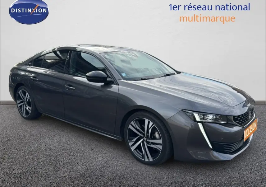 Peugeot 508 gris platinium en 3/4 avant droit, avec jantes alliage bicolores et feux LED distinctifs.