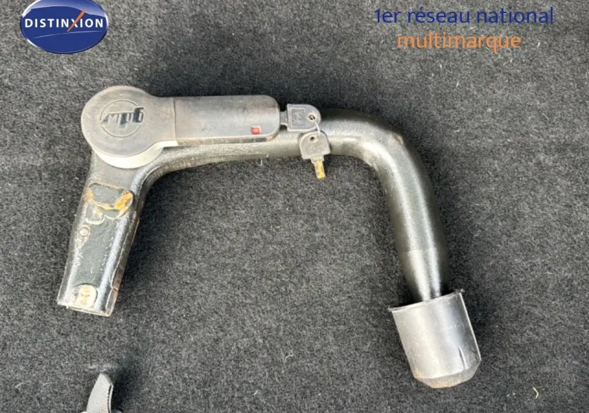 Gros plan sur l'attelage noir amovible posé sur un tapis gris, accessoire distinctif du Peugeot 508 gris platinium.