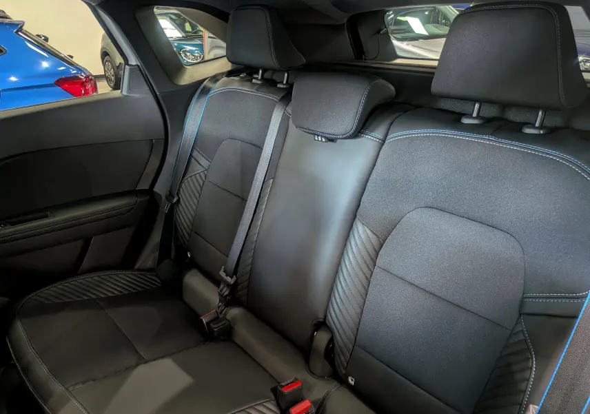 Vue intérieure du siège arrière droit en cuir noir avec surpiqûres bleues du Renault Symbioz E-TECH Full Hybrid 2026.