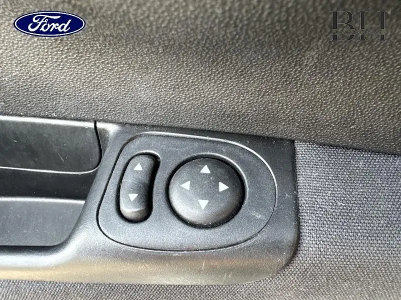 Gros plan sur les commandes de réglage des rétroviseurs noirs à l'intérieur d'une Fiat 500 Lounge 2018 Crossover Black Métal.