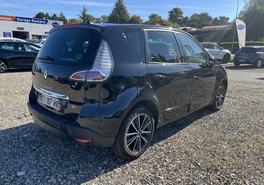 Renault Scénic III noir vu en 3/4 arrière côté gauche, avec jantes alliage et feux arrière caractéristiques.
