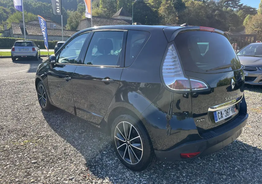 Vue 3/4 arrière droite d'un Renault Scénic III noir de 2012 avec jantes alliage et feux arrière caractéristiques.
