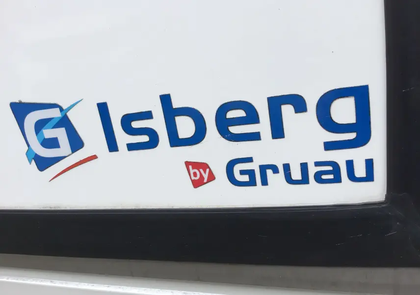 Gros plan sur le logo bleu Isberg by Gruau sur la caisse frigorifique blanche du Renault Trafic Plancher Cabine.