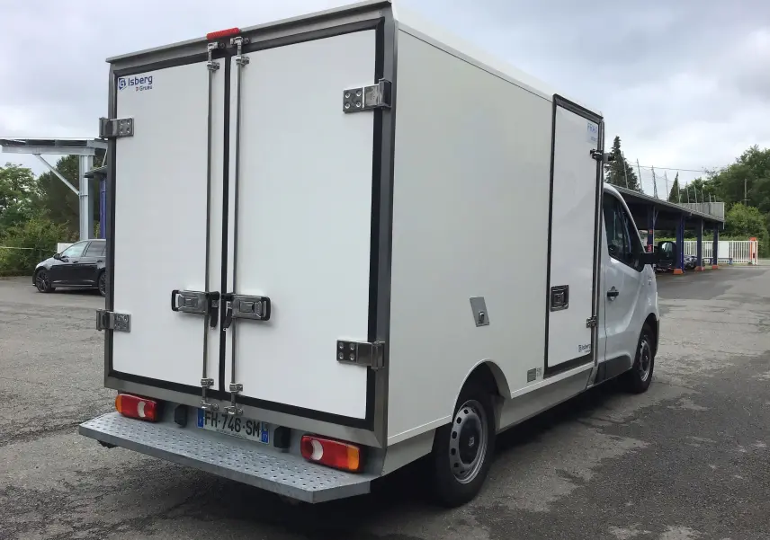 Vue 3/4 arrière droite d'un Renault Trafic blanc avec caisse frigorifique Iceberg by Gruau et porte latérale.