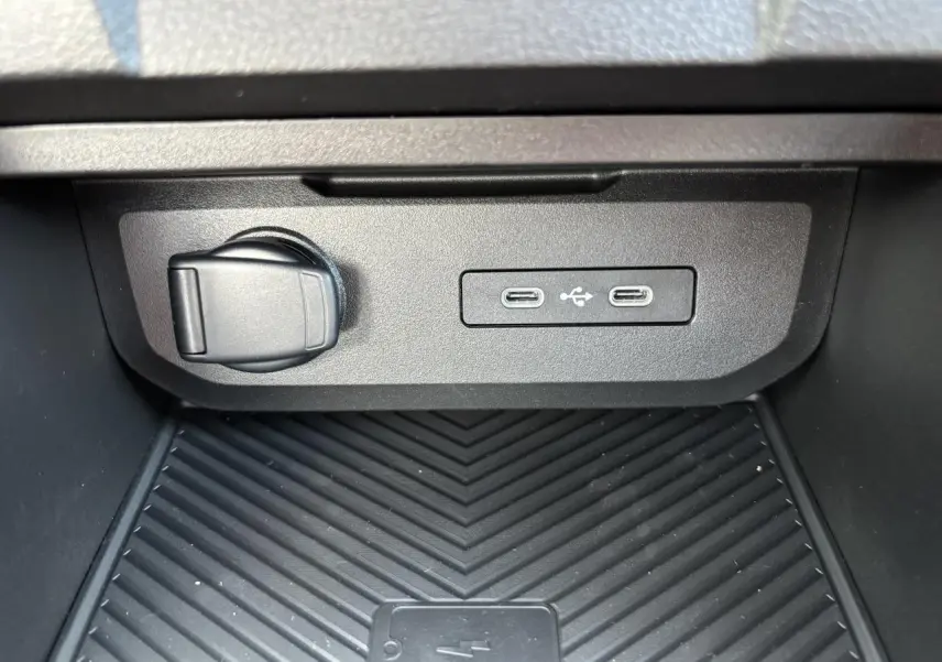 Prise 12V, deux ports USB-C et surface de charge à induction dans la console centrale du Dacia Duster Vert Cèdre.