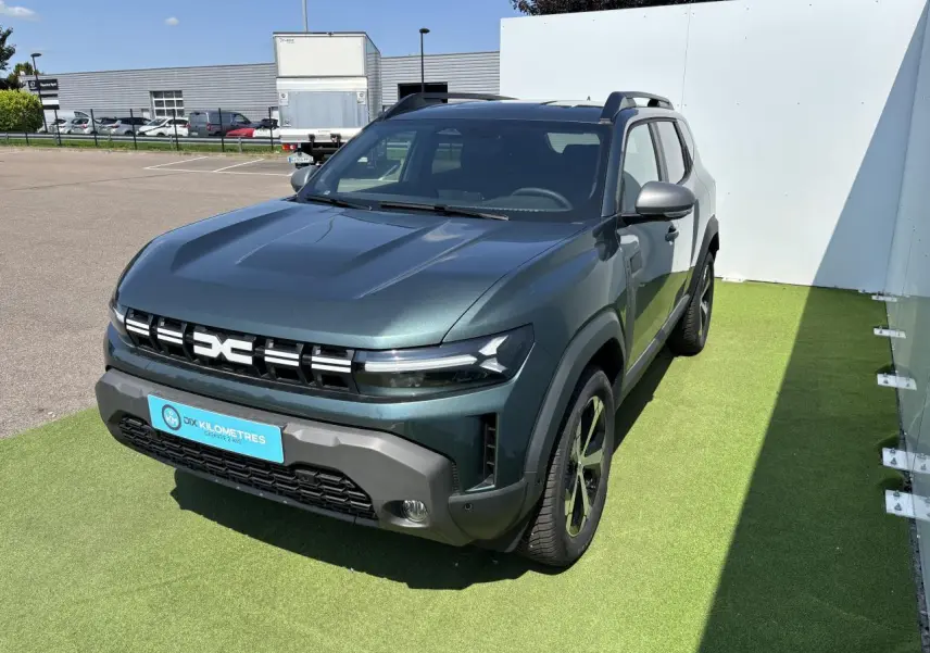 Dacia Duster III vert cèdre métal vu en 3/4 avant droit avec calandre distinctive et jantes alliage.