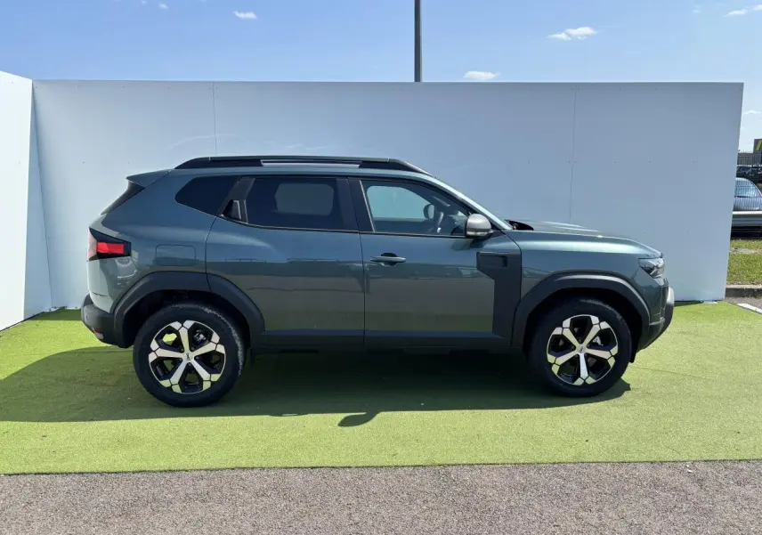 Profil côté gauche du SUV Dacia Duster 2025 en Vert Cèdre Métal avec jantes alliage 18 pouces diamantées.