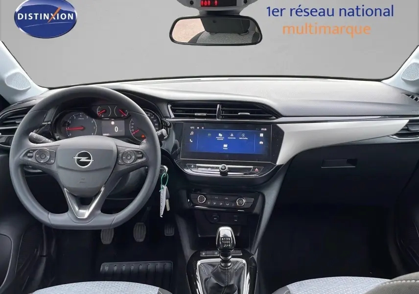 Intérieur de l’Opel Corsa 2025 blanc arctique, vue frontale du tableau de bord avec volant multifonction et écran tactile central.