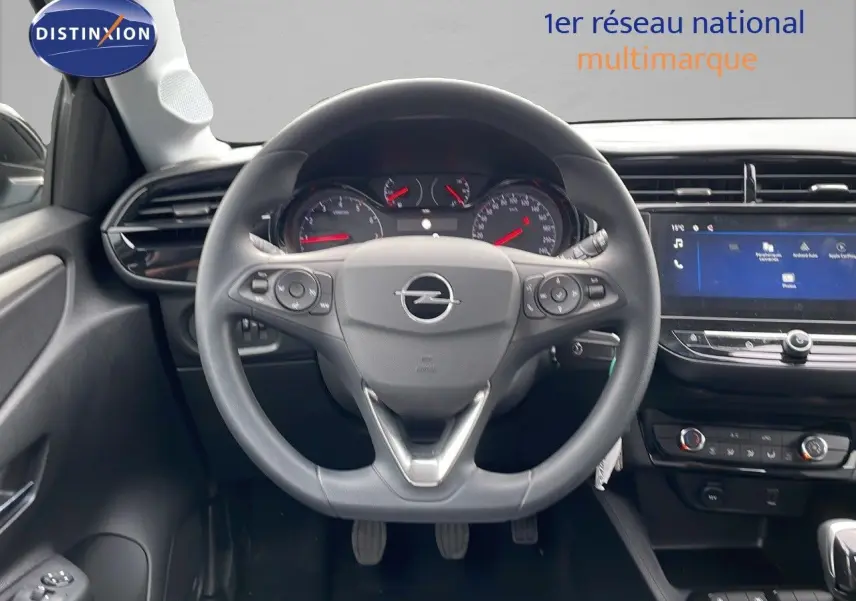 Vue intérieure centrée sur le volant Opel Corsa blanc arctique 2025 avec tableau de bord et écran tactile.