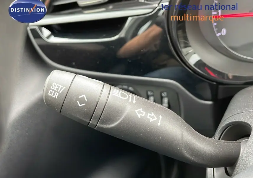 Gros plan sur la commande de clignotants à gauche du volant dans l'habitacle d'une Opel Corsa blanche 2025.