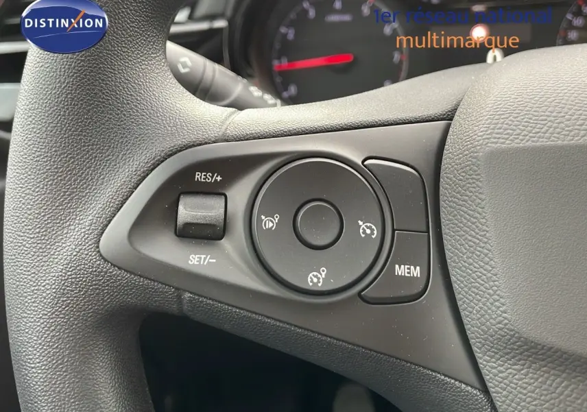 Gros plan sur les commandes de régulateur de vitesse au volant d'une Opel Corsa blanche Arctic 2025.