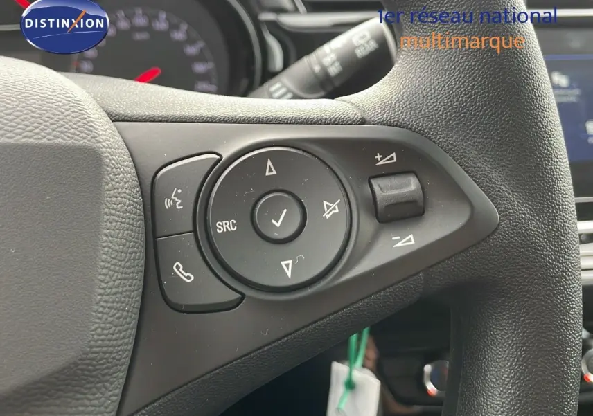 Gros plan sur les commandes multifonctions du volant en cuir noir d'une Opel Corsa blanche Arctic 2025.