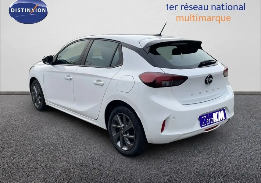 Opel Corsa blanc arctique vue 3/4 arrière droit, avec jantes gris foncé et feux arrière LED foncés.