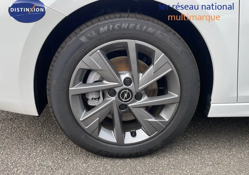 Gros plan sur la roue avant droite blanche d'une Opel Corsa 2025 avec jante alliage grise et pneu Michelin.