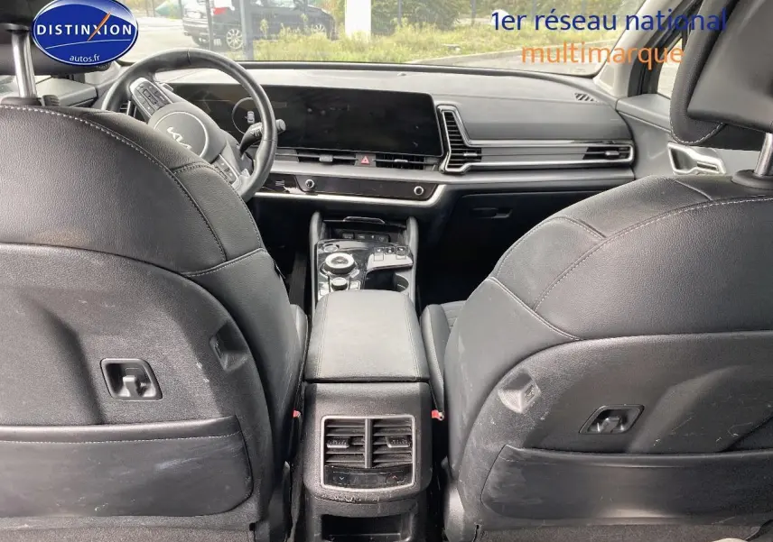 Vue arrière de l'intérieur noir du Kia Sportage 2023, montrant les sièges avant et la console centrale moderne.