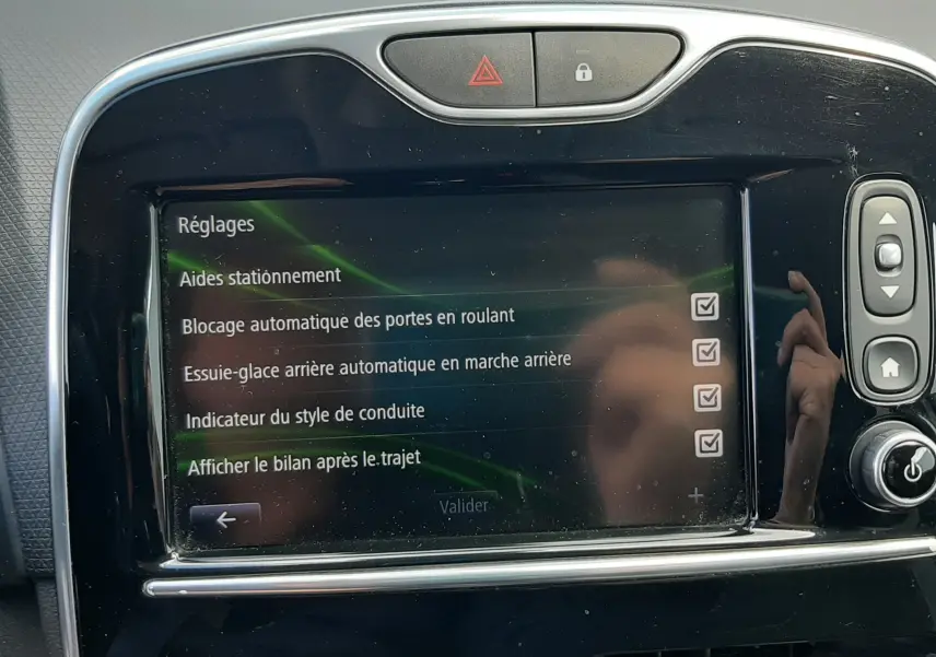 Écran tactile central de la Renault Clio IV Estate beige 2016 affichant les réglages d’aides à la conduite.