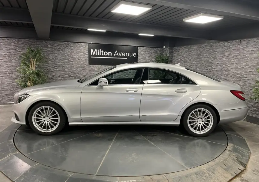 Profil droit d'une Mercedes Classe CLS 350 d gris métallisé avec jantes alliage multibranches en showroom.