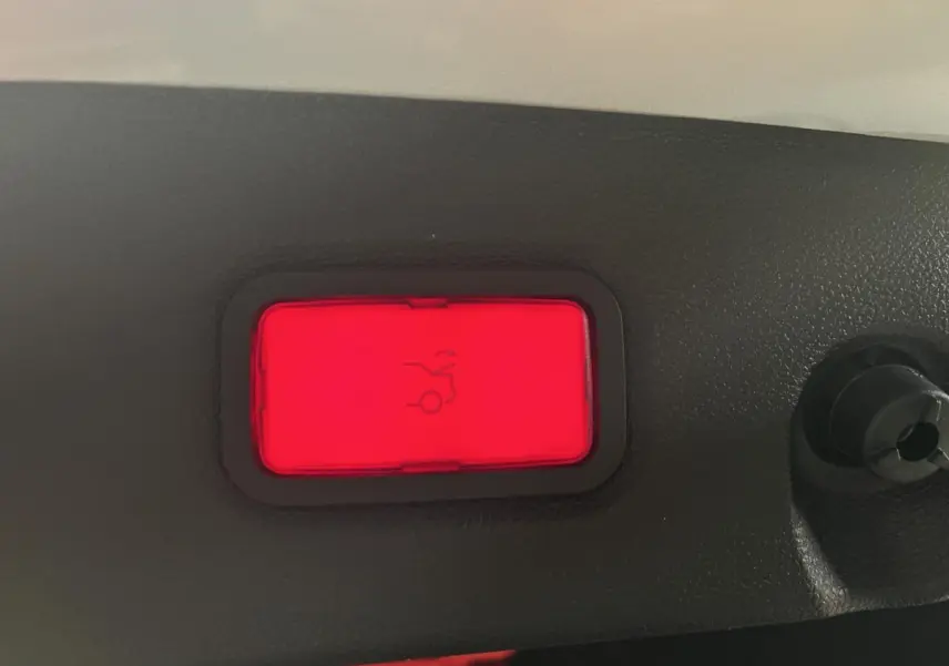 Bouton rouge d'ouverture électrique du hayon sur la garniture intérieure d'une Mercedes CLS 350 d gris