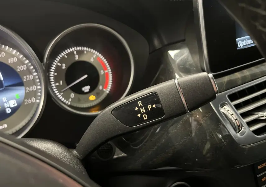 Gros plan sur le levier de boîte auto 9G-Tronic dans l'habitacle noir du Mercedes CLS 350 d gris de 2015.