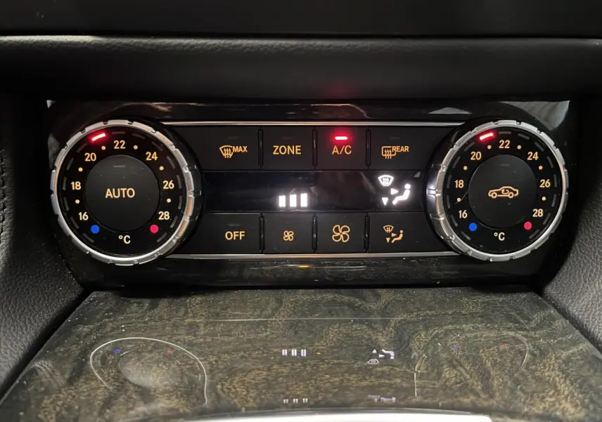 Panneau de climatisation automatique bi-zone avec réglages numériques et finition bois sombre dans une Mercedes CLS 350 d gris.