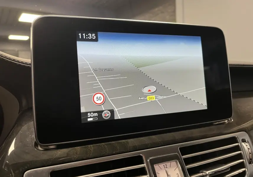 Écran de navigation Garmin MAP PILOT affichant une carte, intégré au tableau de bord en bois clair d'une Mercedes CLS 350 d gris.