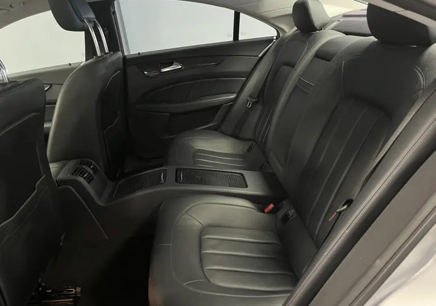 Vue intérieure des sièges arrière en cuir noir de la Mercedes CLS 350 d gris, avec accoudoir central et finitions élégantes.