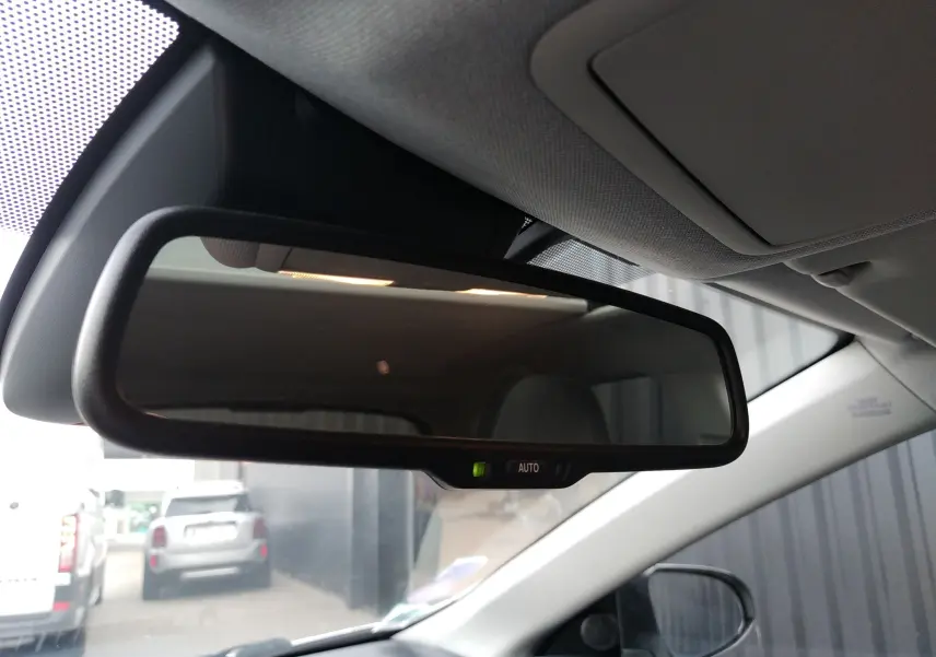 Rétroviseur intérieur automatique d'une Toyota Auris blanche, vue depuis le siège conducteur vers l'avant du véhicule.