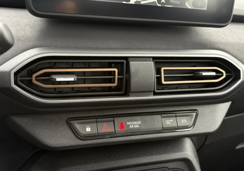 Gros plan sur les aérateurs centraux du tableau de bord de la Dacia Sandero Stepway 2025, avec détails beige Safari.