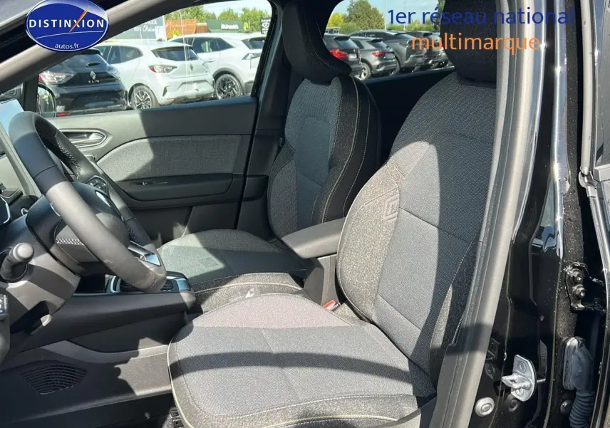 Vue intérieure côté gauche du Renault Captur 1.6 e-tech hybride 2025 avec sièges tissu gris et accoudoir central.
