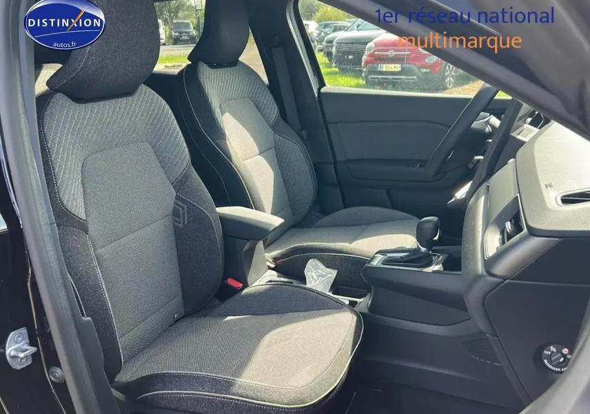 Vue intérieure côté gauche du Renault Captur 1.6 e-tech hybride 2025 avec sièges tissu gris et console centrale noire.
