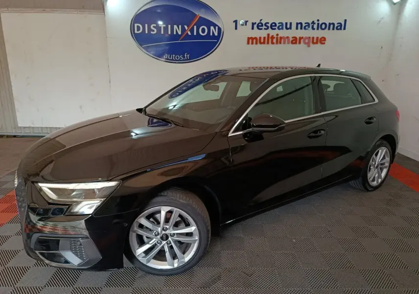 Audi A3 35 TDI noir vue 3/4 avant droit en intérieur, avec jantes alliage et phares LED allumés.
