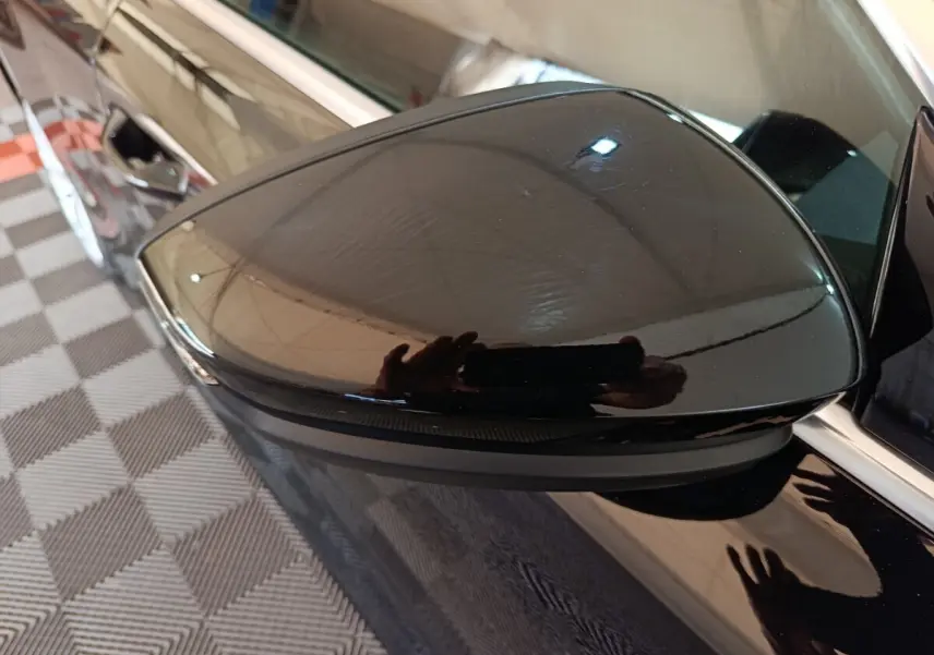 Rétroviseur côté gauche noir brillant de l'Audi A3 35 TDI 150 S tronic Business Line 2023, reflet net sur carrosserie noire.